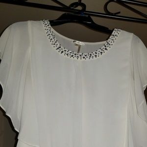 Beige chiffon blouse with embellishments.